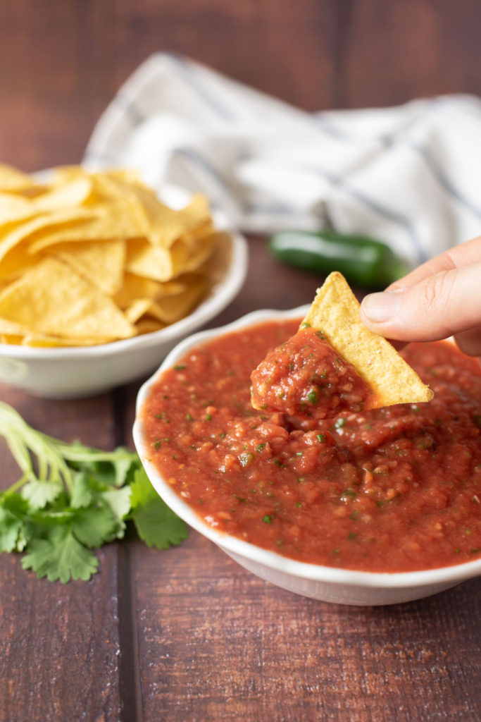 salsa in a bowl and scooped with a tortilla chip